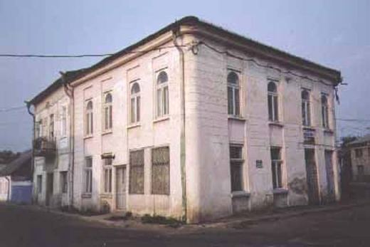 A two-storey white building on a street corner