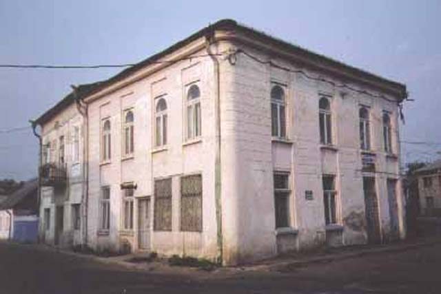 A two-storey white building on a street corner