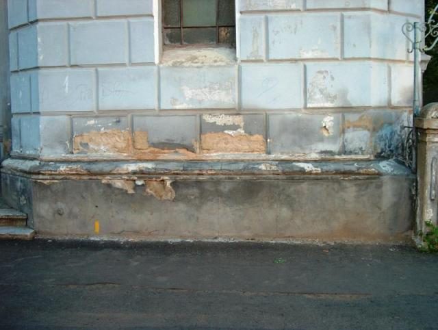 The base of the wall with peeling plaster