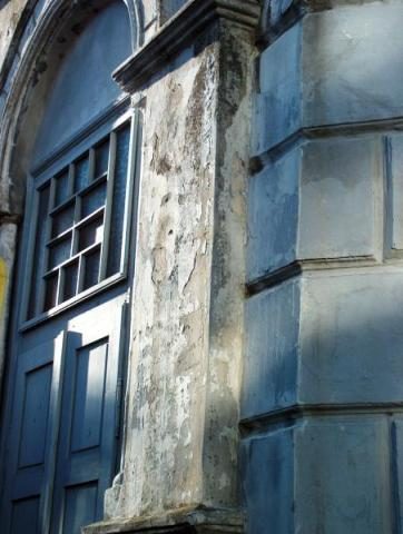 A weathered pilaster beside a tall window